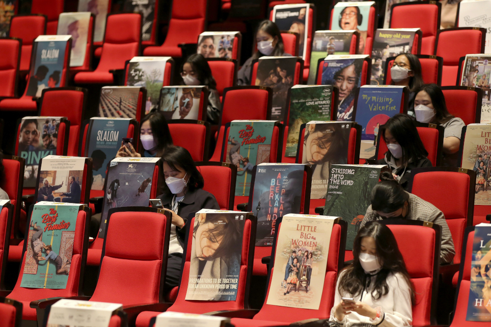 Visitors sitting among movie posters to observe social distancing as they attend at a public talk about South Korean zombie thriller u00e2u20acu02dcPeninsulau00e2u20acu2122 during the BIFF 2020 at the Busan Cinema Centre in Busan October 21, 2020. u00e2u20acu201d BIFF handout pic via AFP