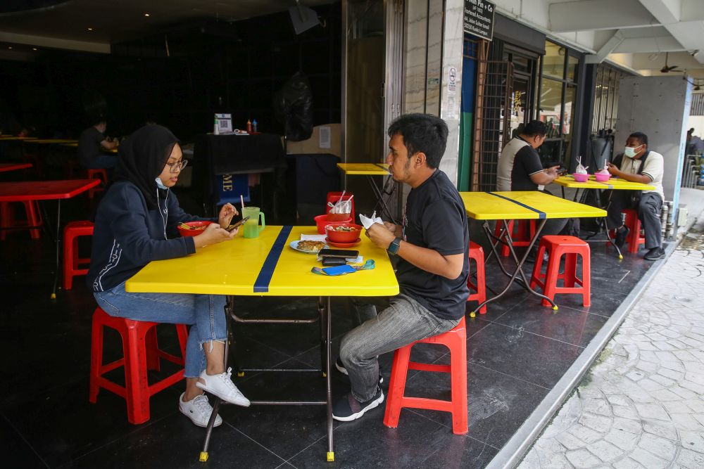 Makan di restoran atau kedai makan terhad kepada dua orang semeja sepanjang tempoh PKPB bermula hari ini hingga 27 Oktober depan. — Foto oleh Yusof Mat Isa