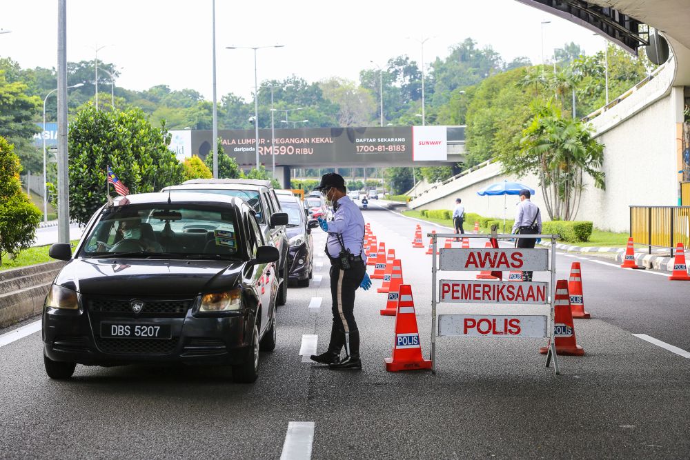 A traffic policeman conducts checks on vehicles during a roadblock on Jalan Sultan Ismail in Kuala Lumpur October 14, 2020. — Picture by Yusof Mat Isa