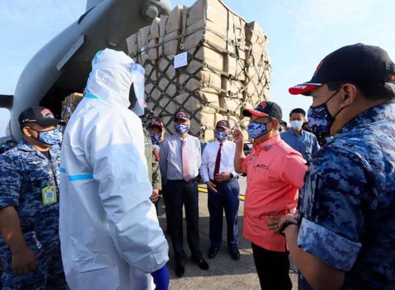 Prime Minister Tan Sri Muhyiddin Yassin speaks to a member of the Malaysian Air Force while inspecting supplies for Sabah and Sarawak at the Subang Air Base October 30, 2020. u00e2u20acu2022 Picture via Facebook