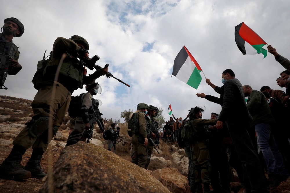 Demonstrators hold Palestinian flags in front of Israeli troops during a protest against Jewish settlements and US President Donald Trump, in Beit Dajan in the Israeli-occupied West Bank November 6, 2020. u00e2u20acu201d Reuters pic