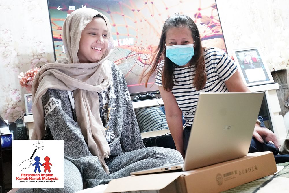 Nur Afifah Mat Nawi (left) looks happy to receive a new laptop. u00e2u20acu201d Picture courtesy of Childrenu00e2u20acu2122s Wish Society of Malaysia
