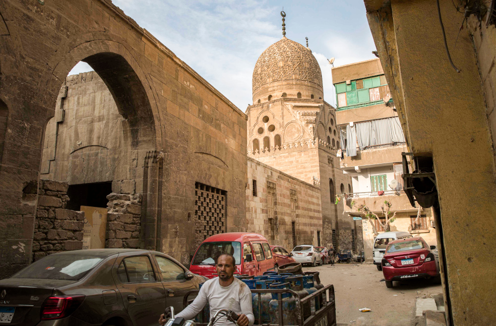 A man drives a motorcycle cart loaded with butane gas cylinders near the 15th century Sultan Qaitbay mosque complex in the u00e2u20acu02dcDesert of the Mamluksu00e2u20acu2122 (City of the Dead) area of Egyptu00e2u20acu2122s capital Cairo November 1, 2020. u00e2u20acu201d AFP picnn