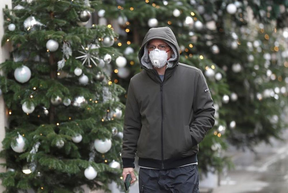 A man walks past Christmas decorations outside a store amid the coronavirus disease outbreak in London Britain
