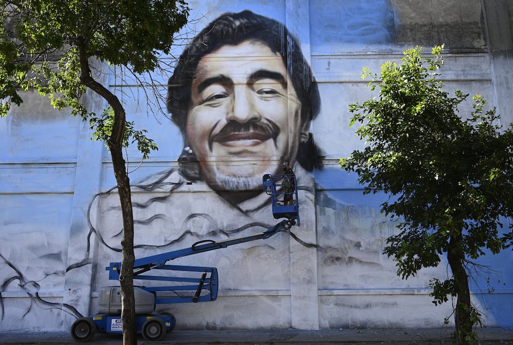 Argentine street artist Alfredo Segatori controls an elevator he uses to paint a mural of late Argentine football legend Diego Maradona in Buenos Aires December 1, 2020. u00e2u20acu201d AFP pic