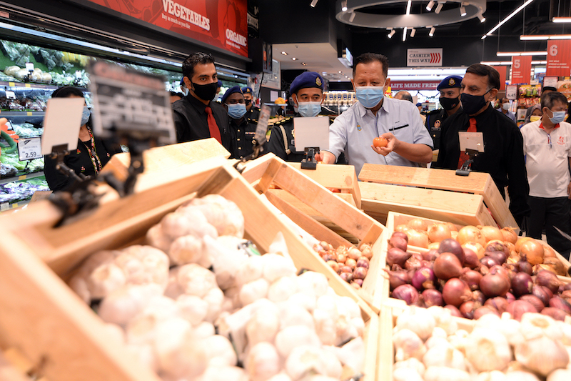 Trade, Industry and Entrepreneurial Development Committee chairman Datuk Abdul Halim Hussain (middle) checking on prices of goods at Sam's Groceria, Penang. — Picture by Steven Ooi K.E.