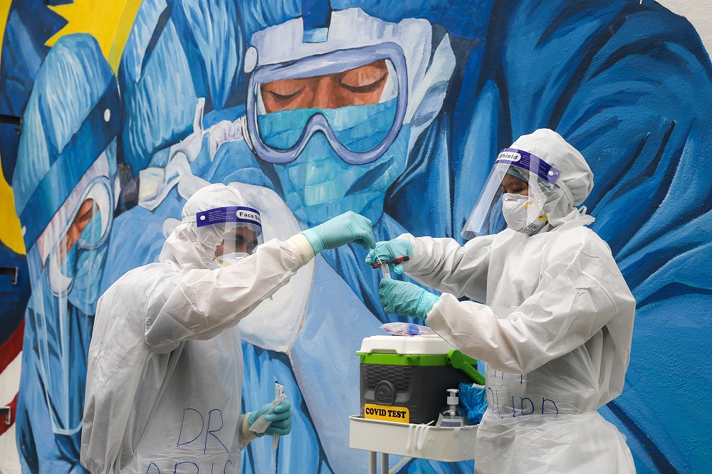 Health workers in protective suit collect swab samples to be tested  for Covid-19 in Shah Alam December 8, 2020. ―Picture by Yusof Mat Isa