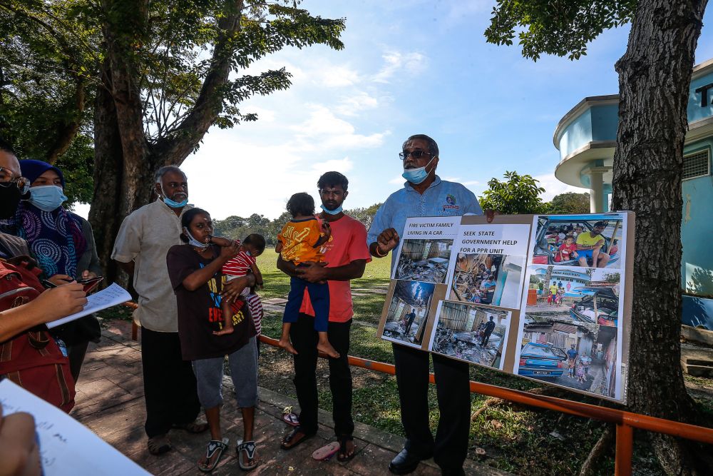 S. Ganesh (second from right) is is appealing for a public housing unit, having had to live out of his car after his house on Carnarvon Street caught fire in April. — Picture by Sayuti Zainudin