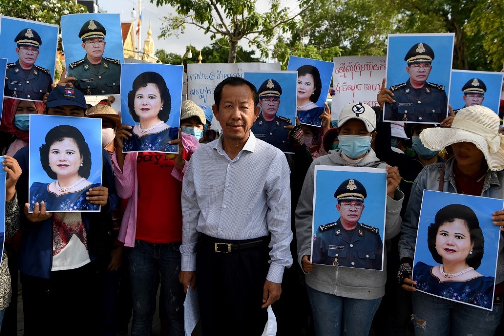 Rong Chhun (centre), president of Cambodiau00e2u20acu2122s Independent Teachersu00e2u20acu2122 Association, stands with protesters holding placards of Cambodiau00e2u20acu2122s Prime Minister Hun Sen and his wife Bun Rany, in Phnom Penh July 29, 2020. u00e2u20acu201d AFP pic