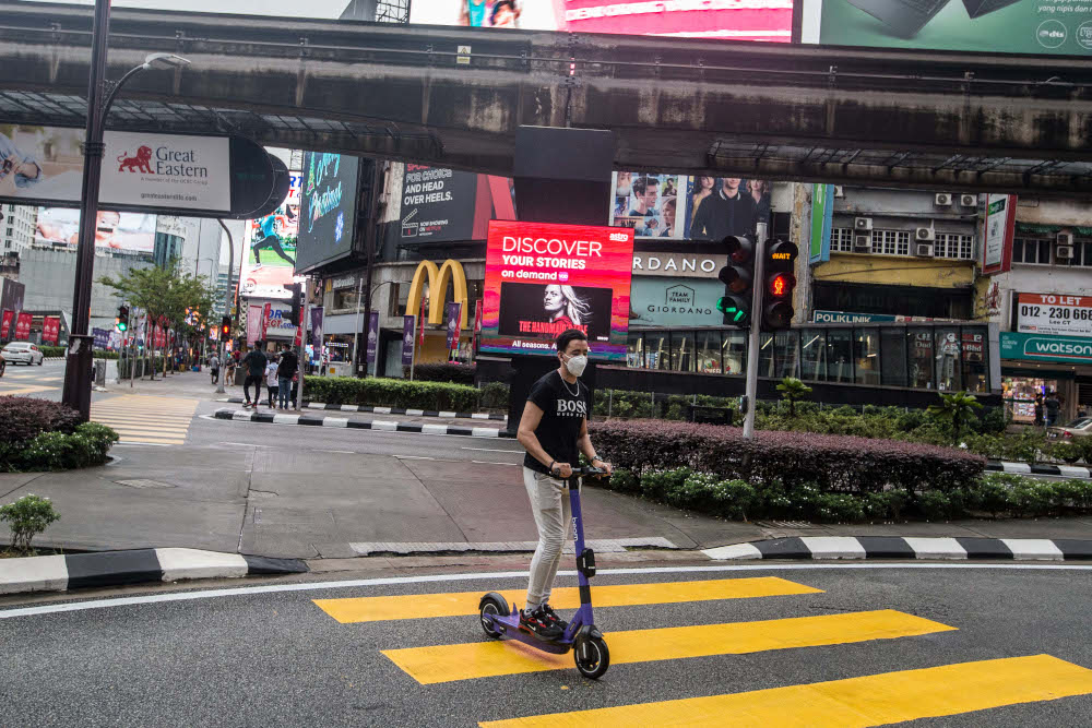 A man wearing a protective face mask rides an electric scooter in Bukit Bintang, Kuala Lumpur January 3, 2021. u00e2u20acu201d Picture by Firdaus Latif