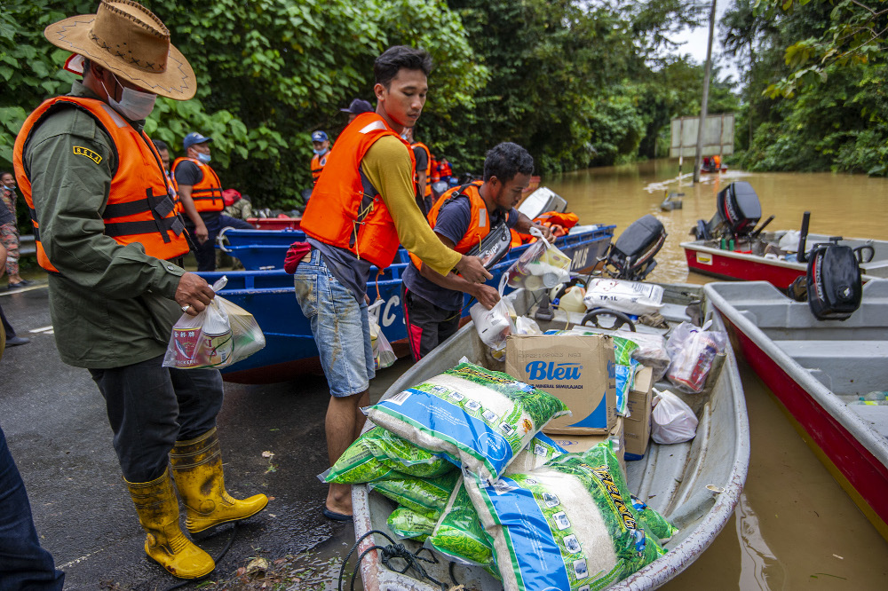 Local volunteers deliver food supplies by boat for the stranded flood victims at Kampung Chenor, Maran in Pahang January 10, 2021. u00e2u20acu201d Picture by Shafwan Zaidon