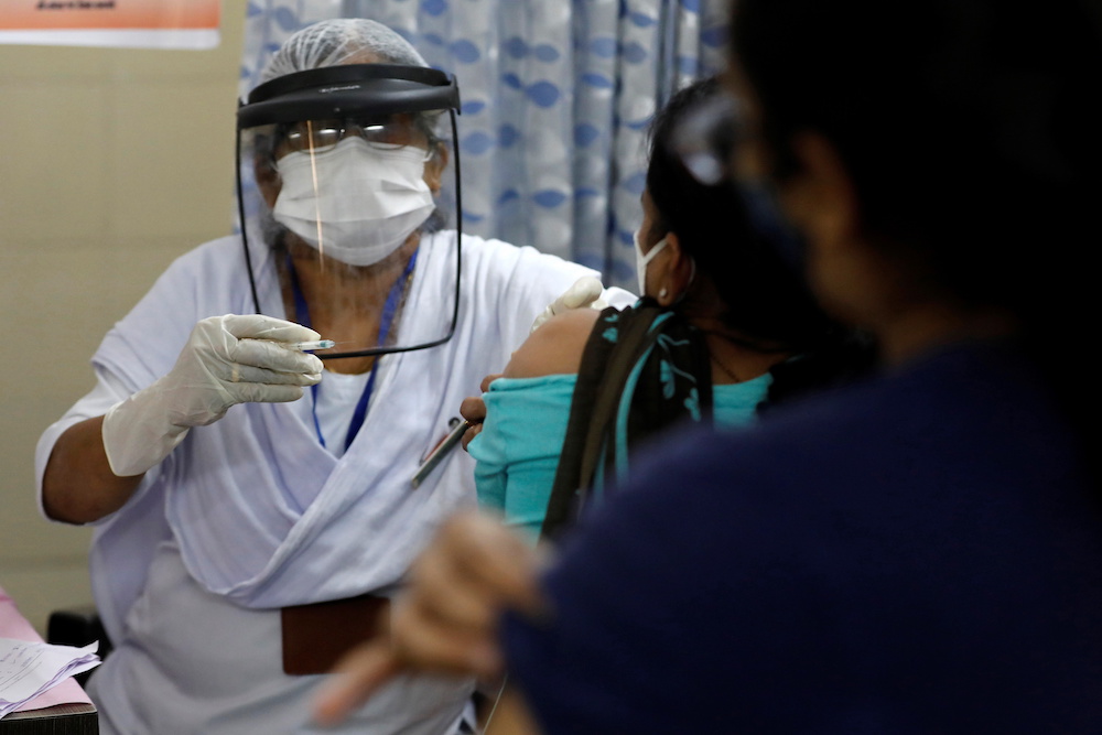 A paramedic wearing a face shield prepares to administer a dose of COVISHIELD, a Covid-19 vaccine manufactured by Serum Institute of India, at a health centre in Jetalpur on the outskirts of Ahmedabad, India, January 16, 2021. u00e2u20acu201d Reuters picnn