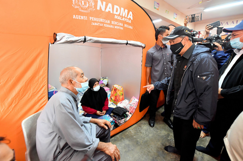 Prime Minister Tan Sri Muhyiddin Yassin mingling with flood victims during a visits at the temporary evacuation centre of Sekolah Menengah Kebangsaan (SMK) Seberang Temerloh Jan 10, 2021. u00e2u20acu201d Bernama pic