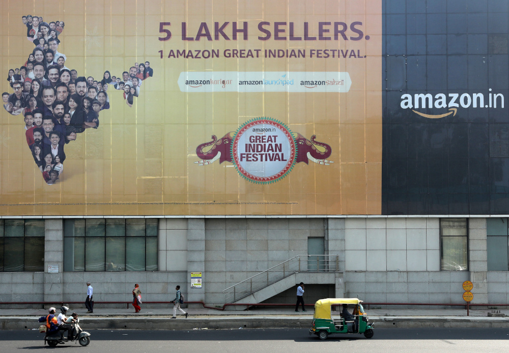 People move past a hoarding of Amazon India outside a metro rail station in New Delhi, India, October 23, 2019. u00e2u20acu201d Reuters picnn