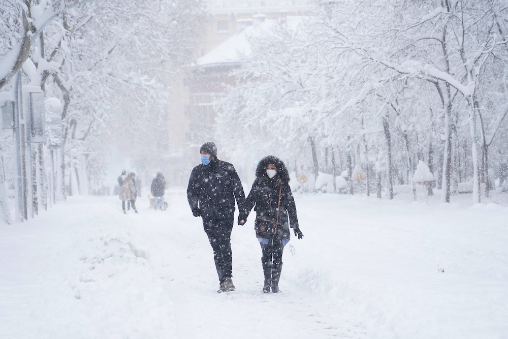 A couple hold hands as they walk on the street during a heavy snowfall in Madrid, Spain, January 9, 2021. u00e2u20acu201d Reuters picnnnn