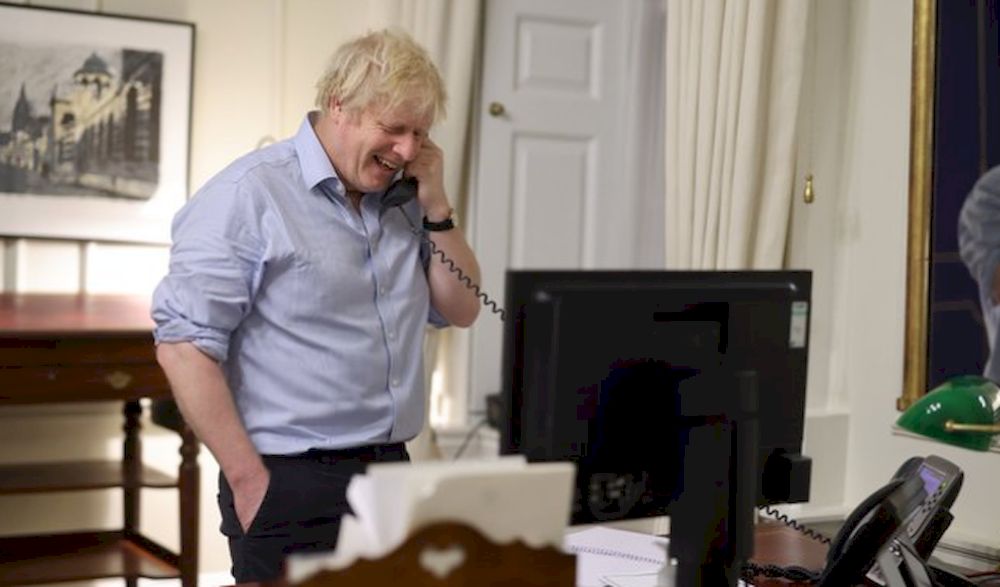Boris Johnson tweeted a picture of himself in shirt-sleeves laughing as he spoke on the phone to US president Joe Biden. — Picture via Twitter/BorisJohnson