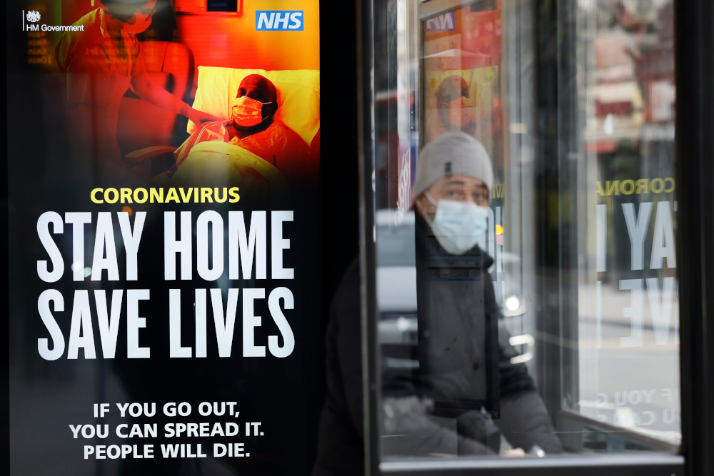 A commuter wears a facemask as he sits in a bus shelter with NHS signage promoting u00e2u20acu02dcStay Home, Save Livesu00e2u20acu2122 in Chinatown, central London January 8, 2021, as England entered a third lockdown due to Covid-19. u00e2u20acu201d AFP pic 