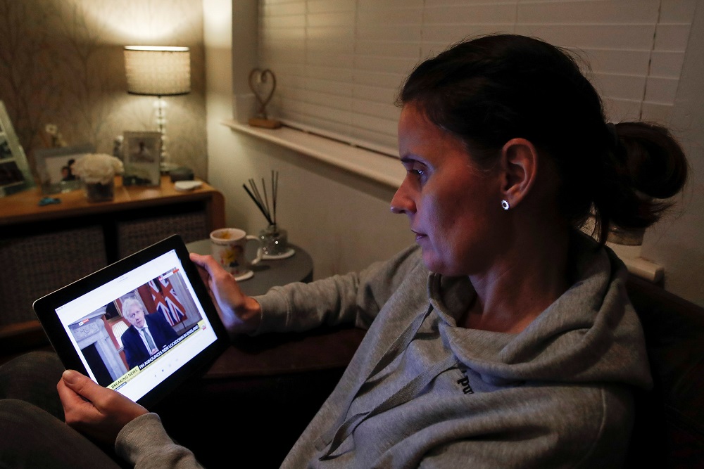 Teacher Wendy Couldridge watches on a device as Britain's Prime Minister Boris Johnson announces a lockdown in England, amid the coronavirus disease outbreak, in Hertford, Britain January 4, 2021. ― Reuters pic