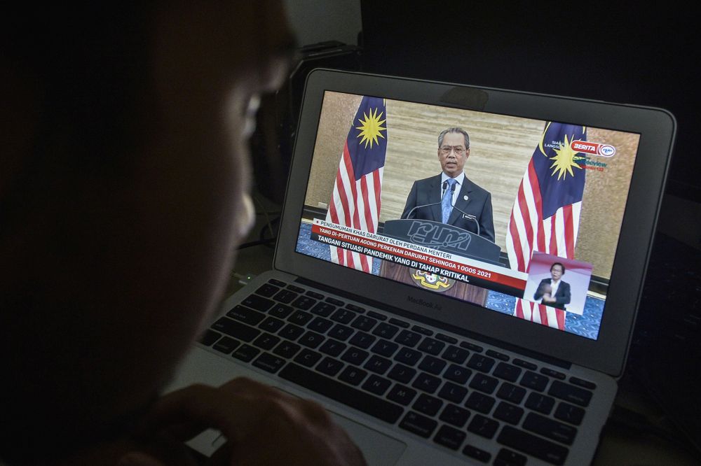 一名男子在2020年1月12日在吉隆坡观看首相丹斯里·穆希丁·亚辛的演讲的直播。