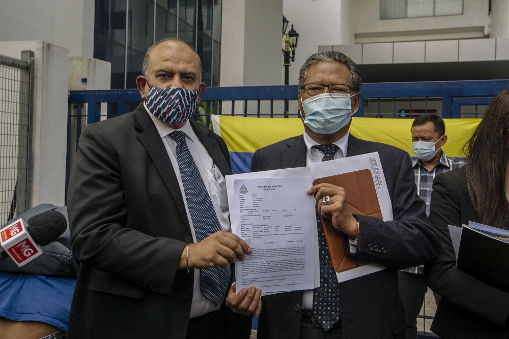 Tan Sri Mohamed Apandi Ali and his lawyer Datuk Baljit Singh Sidhu pose with a copy of the police report against Tan Sri Tommy Thomas in front of the Sentul police headquarters in Kuala Lumpur February 4, 2021. u00e2u20acu201d Picture by Firdaus Latif