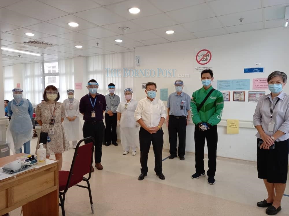 Dr Sim (fourth, right) with the first volunteer (second, right) of the clinical trial for the vaccine developed in China at the SGH CRC today. u00e2u20acu2022 Borneo Post pic