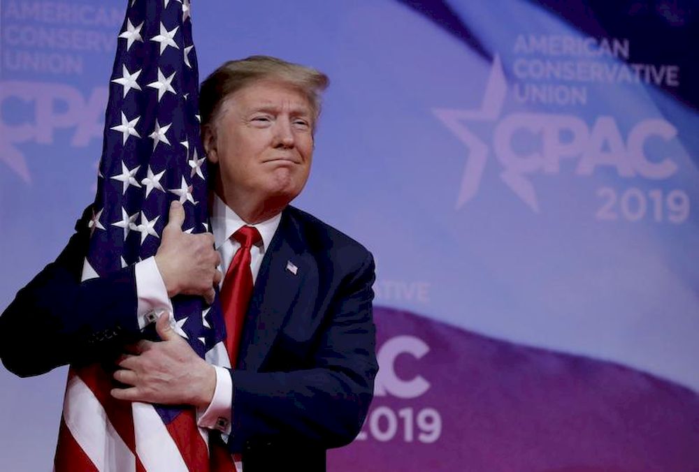 File picture shows President Trump hugging an American flag at the Conservative Political Action Conference annual meeting at National Harbor near Washington, March 2, 2019. u00e2u20acu201d Reuters pic