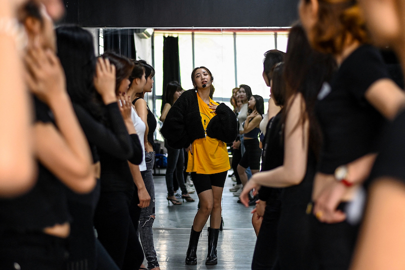This photograph taken on March 2, 2021 shows instructor Pham Kieu Ly (centre) demonstrating a pose to participants during a course teaching them how to pose for photographs on their mobile phones at a studio in Hanoi. u00e2u20acu201d AFP pic