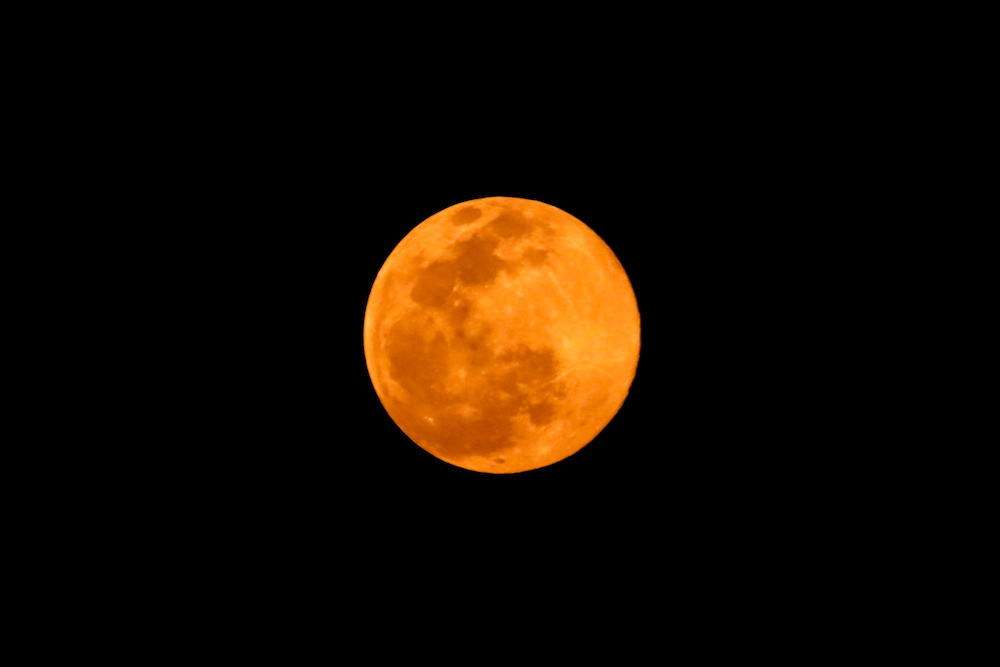 A full moon above the Kathmandu valley looks orange due to air pollution in Kathmandu, Nepal March 28, 2021. — Reuters pic