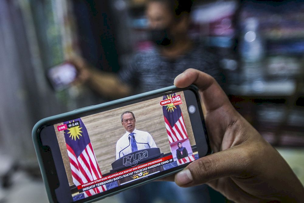 A store keeper at Jalan Tuanku Abdul Rahman watching the live telecast of Prime Minister Tan Sri Muhyiddin Yassin announcing the Pemerkasa programme, March 17, 2021. u00e2u20acu2022 Picture by Hari Anggara