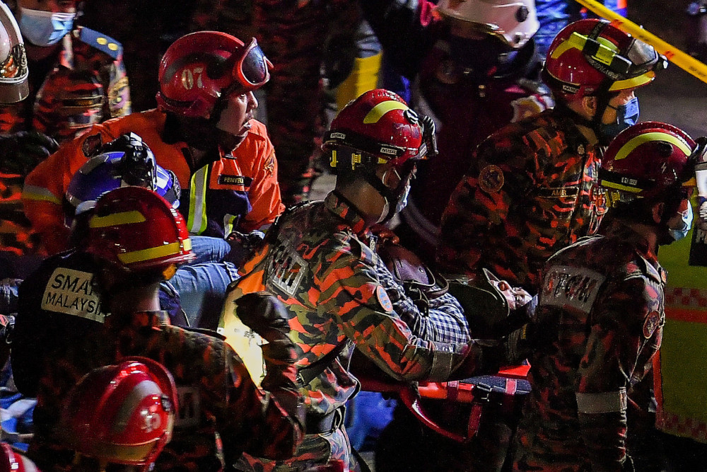 Fire and Rescue Department personnel carry a victim out of the collapsed part of the flyover that was still under construction in Kuala Lumpur, March 3, 2021. u00e2u20acu201d Bernama pic 