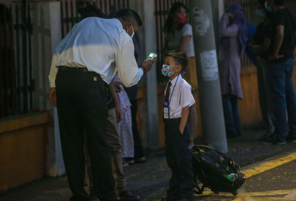 A student has his temperature checked at Sekolah Kebangsaan Cator Avenue, Ipoh as schools reopen March 1, 2021. — Picture by Farhan Najib