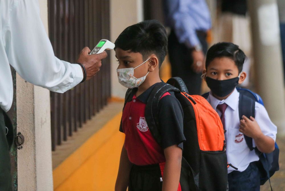 A student has his temperature checked at Sekolah Kebangsaan Cator Avenue, Ipoh as schools reopen March 1, 2021. u00e2u20acu201d Picture by Farhan Najib