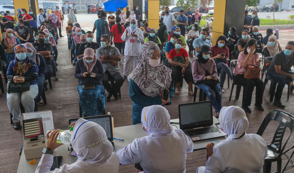 Members of the public wait to receive their Covid -19 jabs at the Indera Mulia Stadium in Ipoh March 16, 2021. u00e2u20acu201d Picture by Farhan Najib