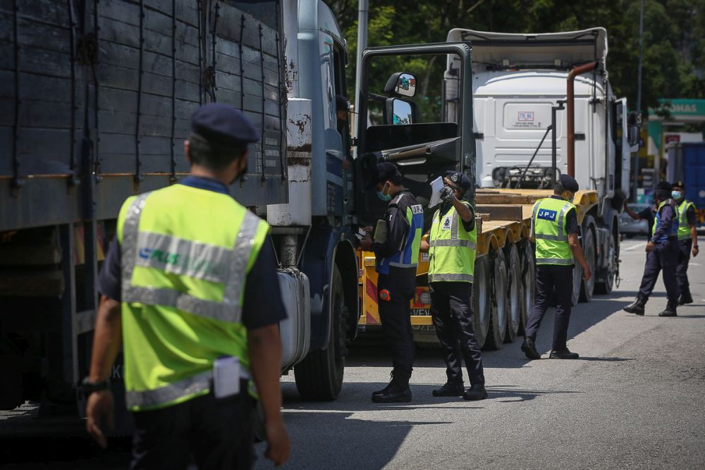 Road Transport Department personnel conduct checks on heavy vehicles during Ops Obstacle at the Bukit Raja Toll Plaza March 10, 2021. u00e2u20acu201d Picture by Yusof Mat Isa