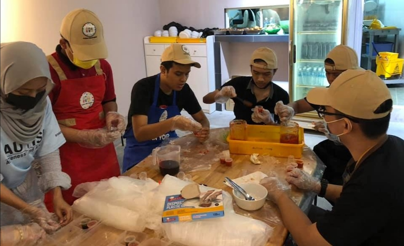 Workers of Autism Cafe Project preparing food at their DaMen outet in USJ. — Photo via Facebook/ Adli Yahya