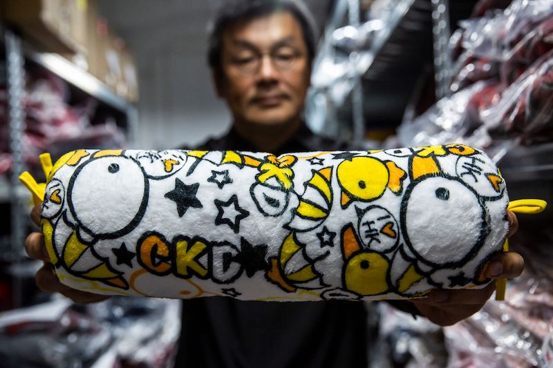 This photo taken on April 9, 2021 shows the owner of clothing brand Chickeeduck, Herbert Chow, holding a cushion his company makes, decorated with chickens and ducklings, in Hong Kong. u00e2u20acu201d AFP pic