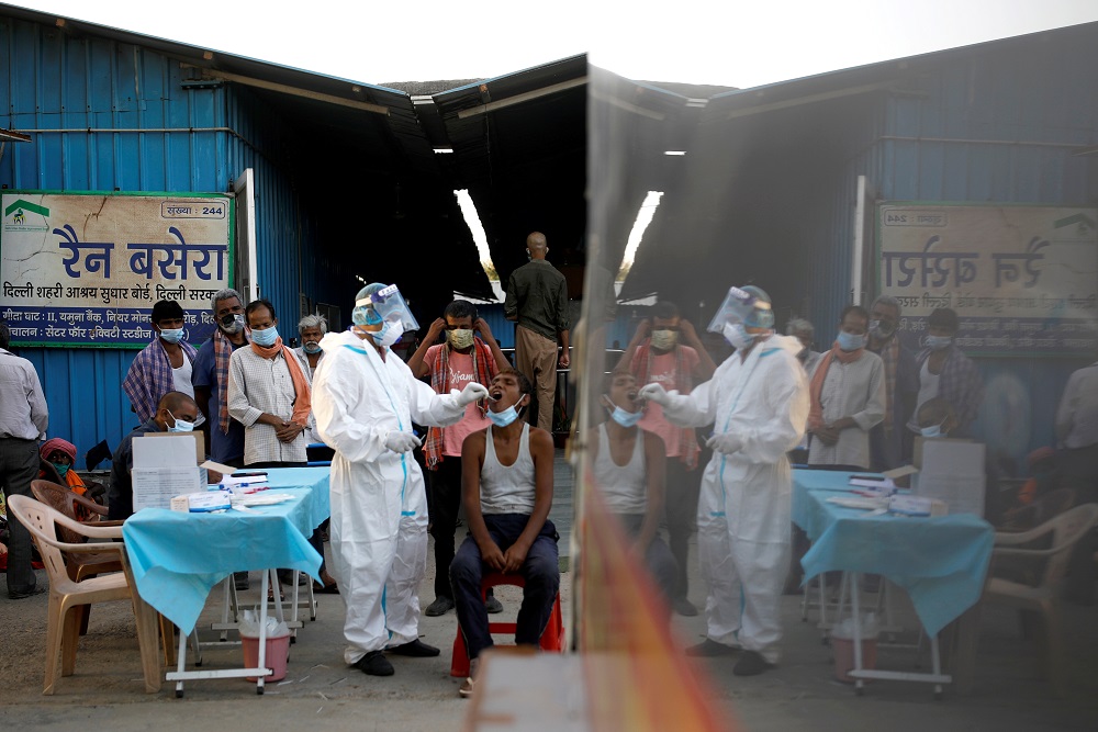 A healthcare worker collects a Covid-19 test swab sample from a man at a temporary shelter for the homeless in New Delhi, India March 31, 2021. u00e2u20acu2022 Reuters file pic