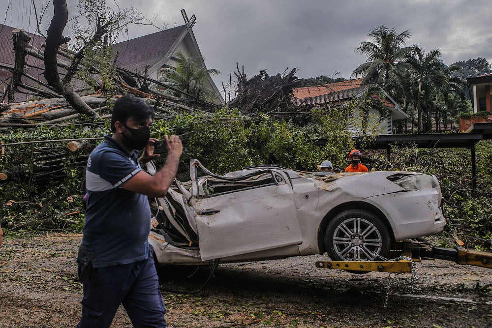 A car was destroyed after being hit by fallen trees during heavy rain at Jalan Travers in front of the National Museum today May 27, 2021. u00e2u20acu201d Picture by Hari Anggara
