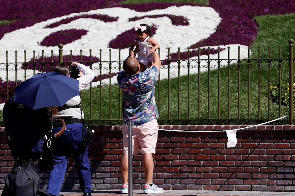 A man holds a child outside Disneyland Park on its reopening day amidst the coronavirus disease outbreak, in Anaheim, California, US, April 30, 2021. u00e2u20acu201d Reuters picnnnn