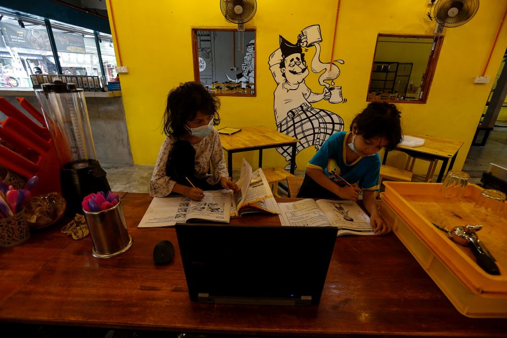 Shamsul Munir Safini's twin daughters Alya and Ayra are seen doing homework at their fatheru00e2u20acu2122s restaurant in Hala Kalui, Seberang Jaya May 17, 2021. u00e2u20acu201d Picture by Sayuti Zainudin