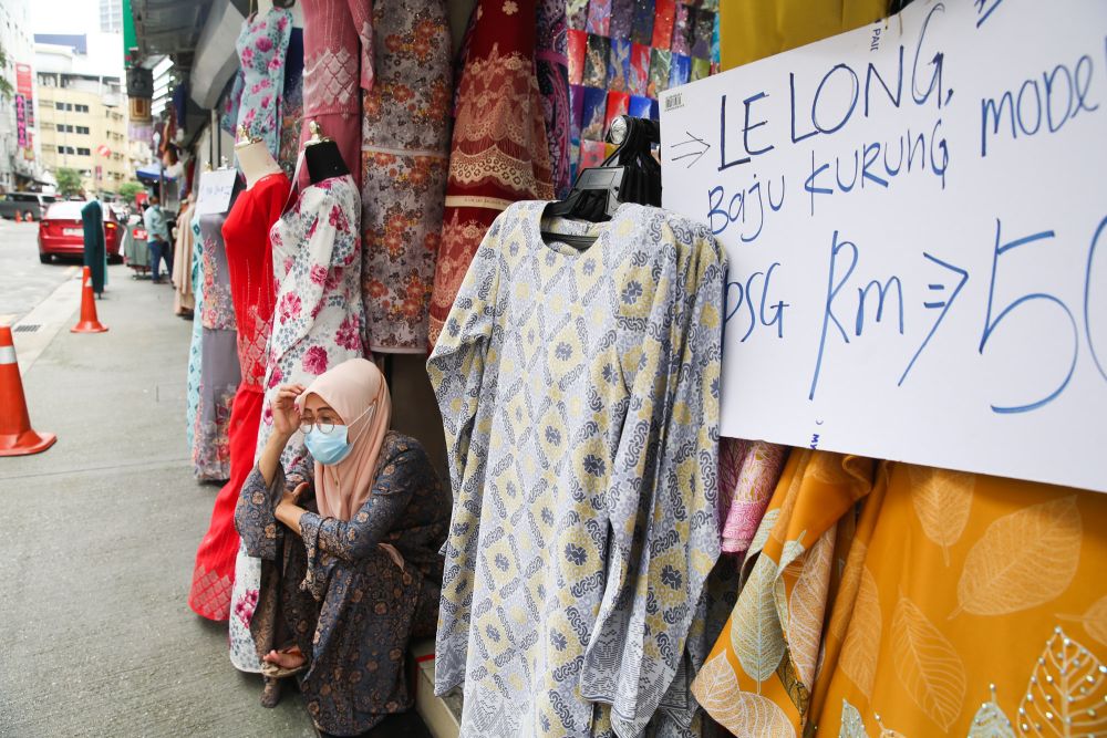 A clothing vendor waits for customers in front of her stall at Jalan Masjid India on the eve of Hari Raya Aidilfitri May 12, 2021. u00e2u20acu201d Picture by Choo Choy May