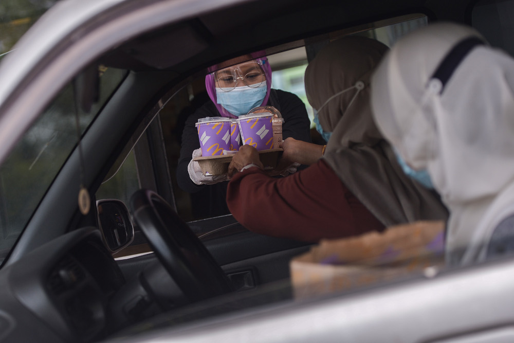 McDonald’s staff deliver the K-pop boyband’s BTS Meals to waiting passengers in Seksyen 3, Shah Alam May 26, 2021. — Picture by Miera Zulyana