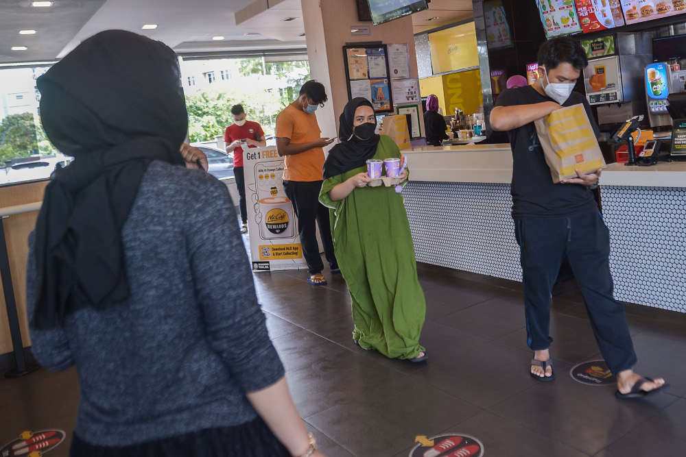 Customers wait in line for their BTS Meals at the McDonald’s outlet in Seksyen 3, Shah Alam May 26, 2021. — Picture by Miera Zulyana