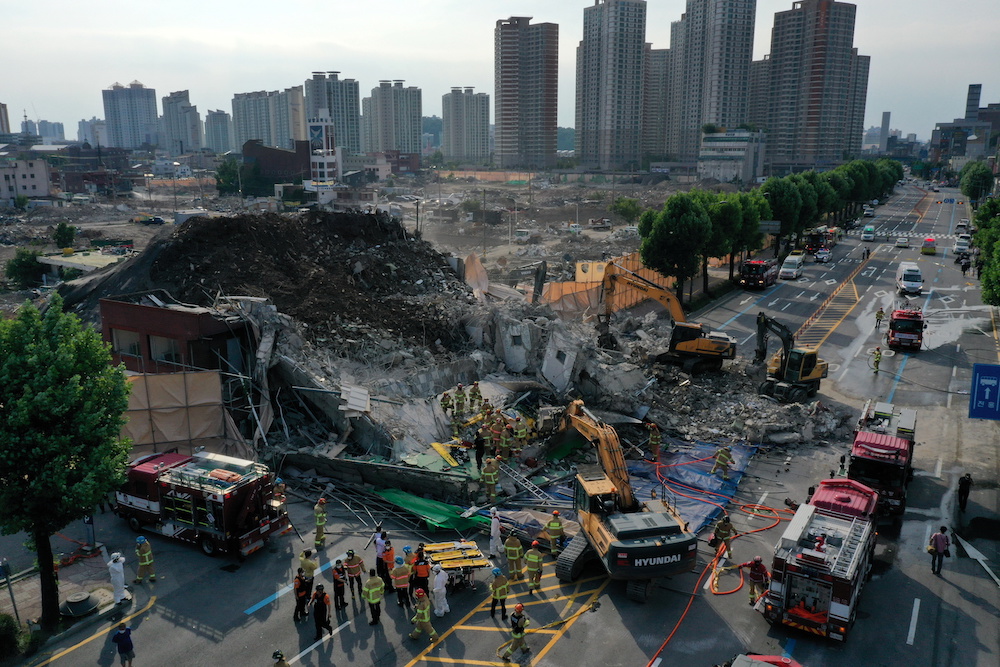 South Korean firefighters search for passengers from a bus trapped by the debris of a collapsed building in Gwangju, South Korea, June 9, 2021. u00e2u20acu201d Yonhap via Reuters