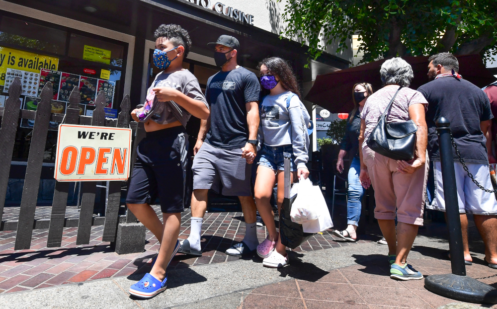 Face masks continue to be worn as people walk past restaurants open for business in Los Angeles June 14, 2021, one day before the state full reopening of its economy since the first statewide shutdown in March 2020 due to the pandemic. u00e2u20acu201d AFP pic 