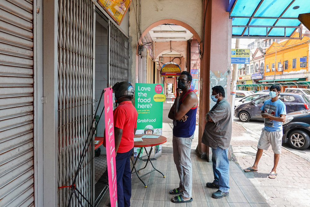 Customers queue outside Restaurant Ghuhan for their takeaway banana leaf meal during the movement control order 3.0 (MCO 3.0) in Klang June 23, 2021. u00e2u20acu201d Picture by Miera Zulyana