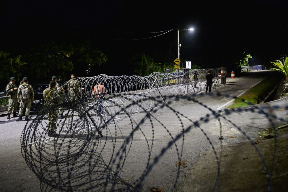 Armed Forces personnel install barbed wire fencing in Kampung Sungai Penchala as the enhanced movement control order kicks in today June 10, 2021. u00e2u20acu201d Picture by Miera Zulyana