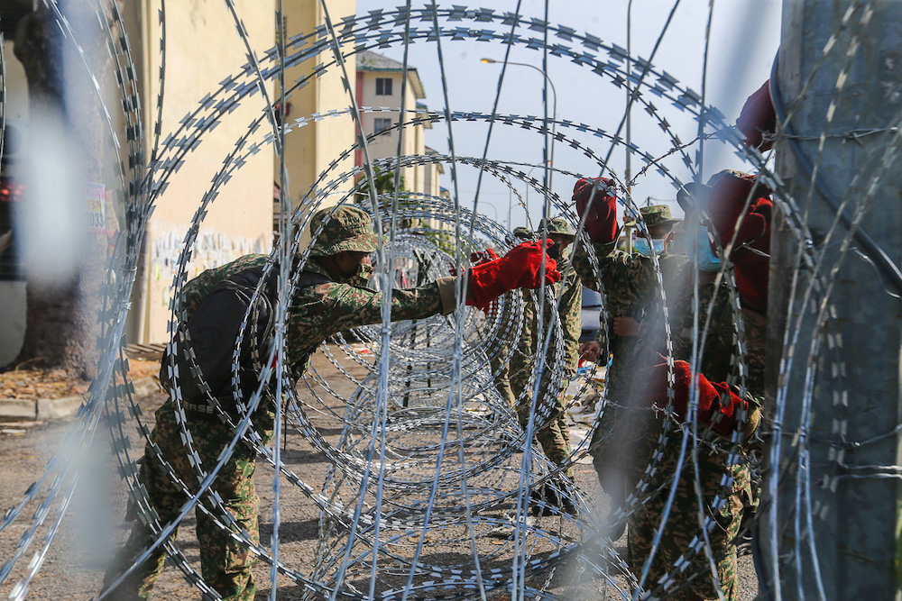 Armed Forces personnel install barbed wire fencing at Pangsapuri Bandar Bukit Tinggi 1, Jalan Nilam 15 during the enhanced movement control order (EMCO) in Klang July 18, 2021. u00e2u20acu201d Picture by Yusof Mat Isa