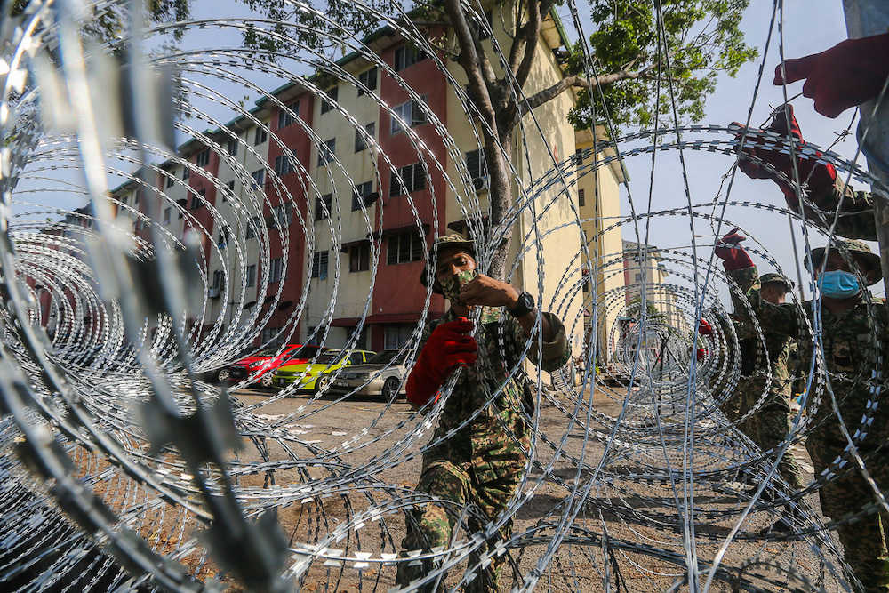 Armed Forces personnel install barbed wire fencing at Pangsapuri Bandar Bukit Tinggi 1, Jalan Nilam 15 during the enhanced movement control order (EMCO) in Klang July 18, 2021. u00e2u20acu201d Picture by Yusof Mat Isa