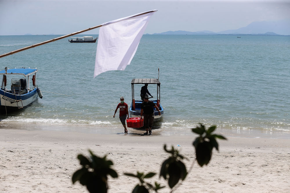 Several fishermen bring the catch of the day which will be distributed to those who are affected by the movement control order at the Tanjong Tokong Fishermen Jetty, Penang July 2, 2021. u00e2u20acu201d Picture by Sayuti Zainudin